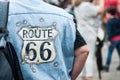 Portrait of Harley Dadidson biker with route 66 blue jeans vest on back view at fun car show event