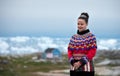 Young inuit woman in traditional clothing posing for photos in a small Greenlandish village. Royalty Free Stock Photo