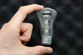 Ilyich bulb, incandescent lamp on a white and black background. In men`s hands. Macro