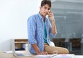 Im always on call. a handsome young man talking on his cellphone while in the office. Royalty Free Stock Photo