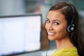 Im connected and listening. Shot of an attractive female with headsets on smiling while looking over her shoulder at Royalty Free Stock Photo