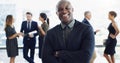 Im doing good. a handsome businessman smiling at the camera while colleagues are blurred in the background. Royalty Free Stock Photo