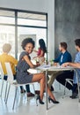 Im glad to be part of such a successful team. Portrait of a young businesswoman in an office meeting with colleagues in Royalty Free Stock Photo