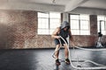 Im going to conquer and crush my goals. a muscular young man working out with battle ropes in a gym. Royalty Free Stock Photo
