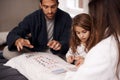 Im going to win this round. a young family playing cards together at home. Royalty Free Stock Photo