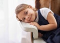 Im gonna be a big girl one day. Portrait of an adorable little girl laying her head on the armrest of a chair.