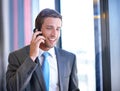 Im happy to take your call anyday. a handsome young businessman talking on his mobile phone at work. Royalty Free Stock Photo