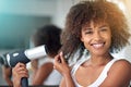 Im having a great hair day. Cropped portrait of a young woman blow drying her hair in the bathroom. Royalty Free Stock Photo