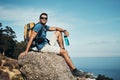 Im just hanging around. Portrait of a carefree young man taking a quick break from hiking up a mountain during the day. Royalty Free Stock Photo