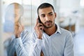 Im listening. a handsome young businessman talking on his cellphone in the office. Royalty Free Stock Photo
