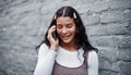 Im on my way. an attractive teenage girl standing alone against a gray wall in the city and using her cellphone.