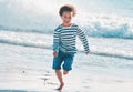 Im not letting the waves catch me. Shot of an adorable little boy running on the beach. Royalty Free Stock Photo