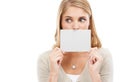 Im not saying a word...Studio shot of a woman holding a blank sign in front of her mouth isolated on white. Royalty Free Stock Photo