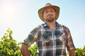 Im outstanding in my field. a middle-aged farmer posing on a vineyard.