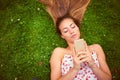 Im at the park...come join me. a young woman using her cellphone while lying on the grass. Royalty Free Stock Photo