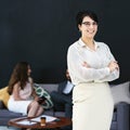 Im a part of the best in the business. Portrait of a young businesswoman standing in a modern office with colleagues in Royalty Free Stock Photo