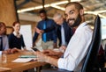 Im part of a great team. a young businessman sitting with a tablet with his colleagues working in the background. Royalty Free Stock Photo