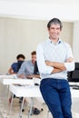 Im proud of this team. Portrait of an office manager smiling at the camera with his coworkers sitting behind him. Royalty Free Stock Photo