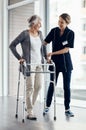 Im so proud of your progress. a female nurse assisting a senior woman using a walker. Royalty Free Stock Photo