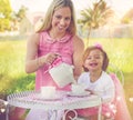 Im raising a little lady. Portrait of a mother and her cute little girl having a tea party on the lawn outside. Royalty Free Stock Photo