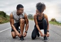 Im ready when you are. a sporty young couple tying their shoelaces while exercising outdoors. Royalty Free Stock Photo