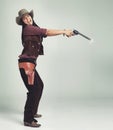 Im the sheriff around these parts...Full-length shot of an attractive young woman in cowboy attire. Royalty Free Stock Photo