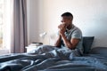 Im sick again. a handsome young man sitting in his bed and blowing his nose while suffering from a cold. Royalty Free Stock Photo