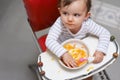 Im still a bit peckish. a cute little baby sitting in a high chair eating. Royalty Free Stock Photo