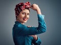 Im a strong, independent woman. Studio portrait of an attractive young woman flexing her bicep while standing against a