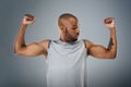 Im strong and thats enough. a sporty young man flexing his muscles against a grey background. Royalty Free Stock Photo