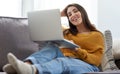 Im such a homebody and I love it. Portrait of a young woman using a laptop while relaxing on a sofa at home.