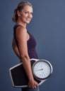 Im tipping the scales back in my favour. Studio portrait of an attractive mature woman holding a weightscale against a Royalty Free Stock Photo