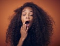 Im tired of haircare products thats not doing what theyre supposed to do. Shot of a young woman with curly hair yawning Royalty Free Stock Photo