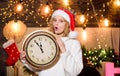 Im waiting. xmas mood. Woman wi clock. girl in red santa claus hat. Midnight. Cheerful woman.. Time to celebrate. winter Royalty Free Stock Photo
