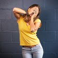 Im waiting...a young woman covering her face against a brick wall background. Royalty Free Stock Photo