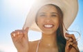 Im wearing my sunhat and my sunny smile. Closeup shot of a beautiful young woman spending some time at the beach.