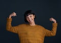 Im a woman, thats my superpower. Studio shot of an attractive young woman flexing her muscles against a dark background.