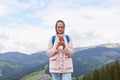 Imag of female tourist holds cell telephone while enjoyinf beautiful landscape of mountains, woman traveler in casual clothes Royalty Free Stock Photo