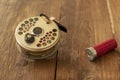 Fly Fishing Reel And Shot Gun Catridge on Old Wood Table