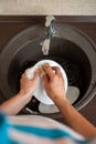 Image from above of man`s hands washing the dish into sink Royalty Free Stock Photo