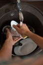 Image from above of man`s hands washing the dish into sink Royalty Free Stock Photo