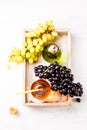 Image from above of wooden tray with green and black grapes, two bottles of juice Royalty Free Stock Photo