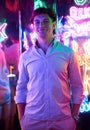 Image of an adult male in an amusement park in a room with neon light. Entertainment concept