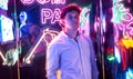 Image of an adult male in an amusement park in a room with neon light. Entertainment concept