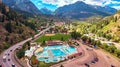 Aerial of majestic natural hot spring in quaint mountain town surrounded by mountains