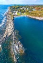 Aerial panorama of endless rocky coasts in Maine with houses, lighthouses, and fall foliage