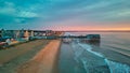 Aerial view over beach in Maine during sunrise with town and old wood pier of shops