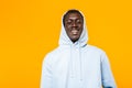 Image of african american guy in streetwear hoodie standing and smiling