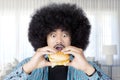 Afro man eating a big cheeseburger at home Royalty Free Stock Photo