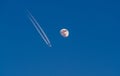 Image of airplane with condensation trails flying next to the detailed moon